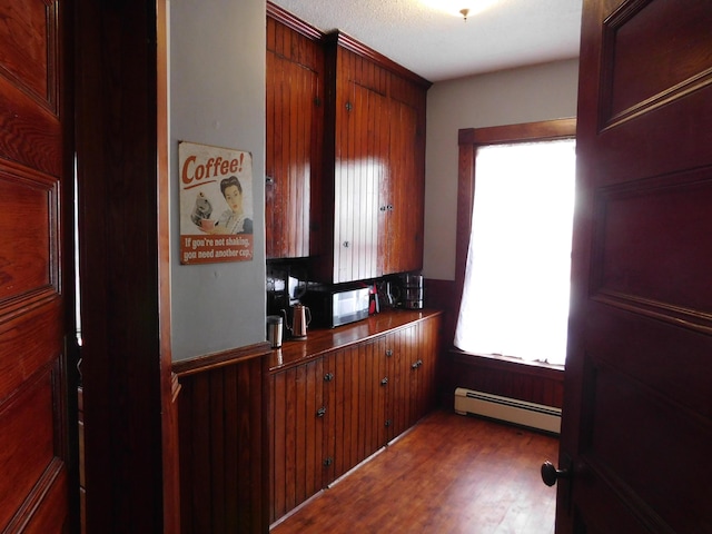 kitchen featuring hardwood / wood-style flooring and a baseboard heating unit