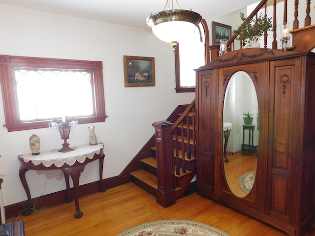 stairway featuring wood-type flooring and ornamental molding