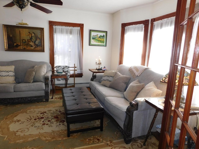 living room with crown molding, a baseboard radiator, and ceiling fan