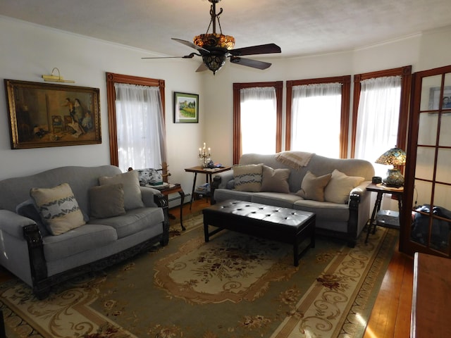 living room featuring crown molding, dark hardwood / wood-style floors, ceiling fan, and baseboard heating