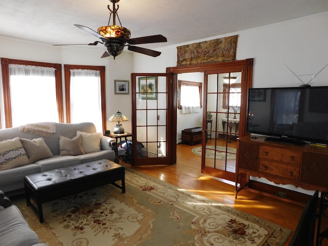 living room featuring hardwood / wood-style flooring, ceiling fan, and a healthy amount of sunlight