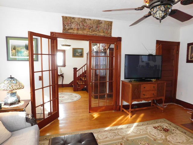 living room with hardwood / wood-style flooring, ceiling fan, and french doors