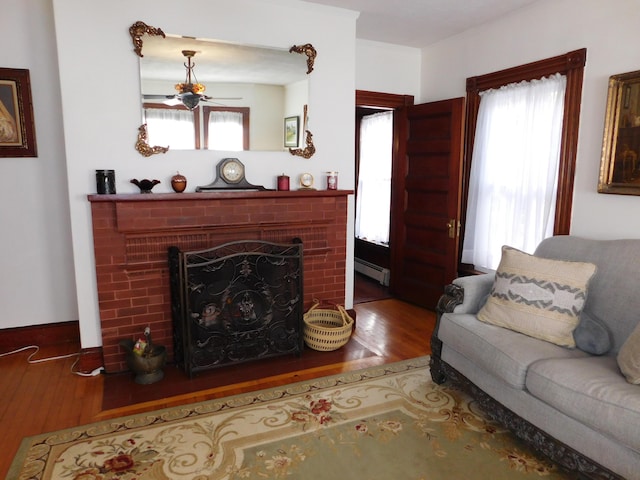 living room with hardwood / wood-style flooring, a fireplace, and baseboard heating