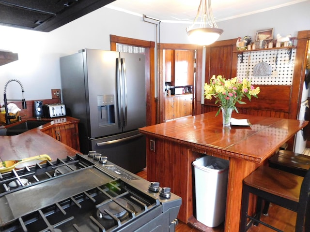 kitchen with stainless steel appliances, ornamental molding, and sink