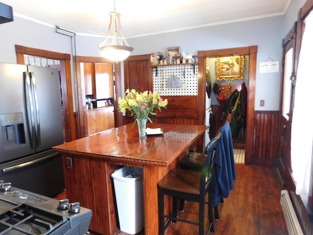 kitchen with wooden walls, a baseboard heating unit, stainless steel fridge with ice dispenser, crown molding, and dark wood-type flooring