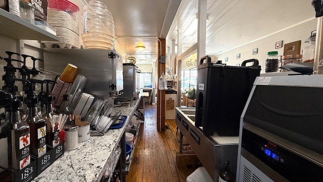 kitchen with dark hardwood / wood-style flooring and light stone countertops