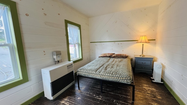 bedroom with heating unit and dark hardwood / wood-style flooring