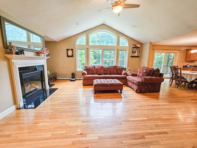 living area with ceiling fan, high vaulted ceiling, light wood-style flooring, a fireplace with flush hearth, and baseboards