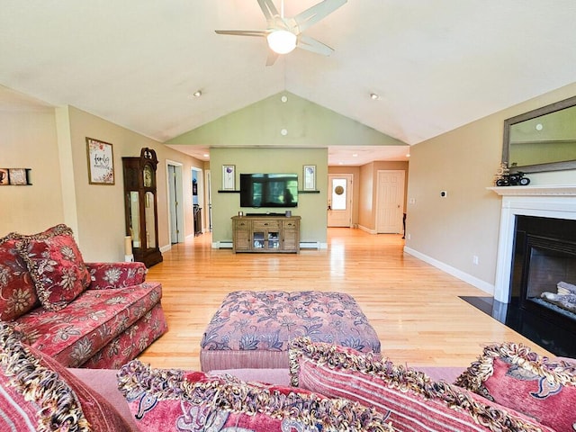 living area featuring lofted ceiling, ceiling fan, wood finished floors, a fireplace with flush hearth, and baseboards