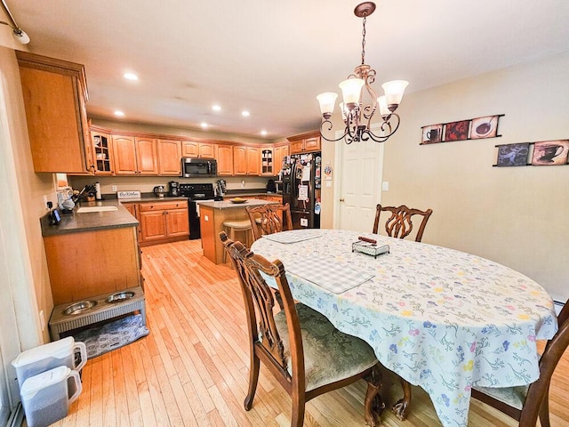 dining space featuring light wood finished floors, a notable chandelier, and recessed lighting