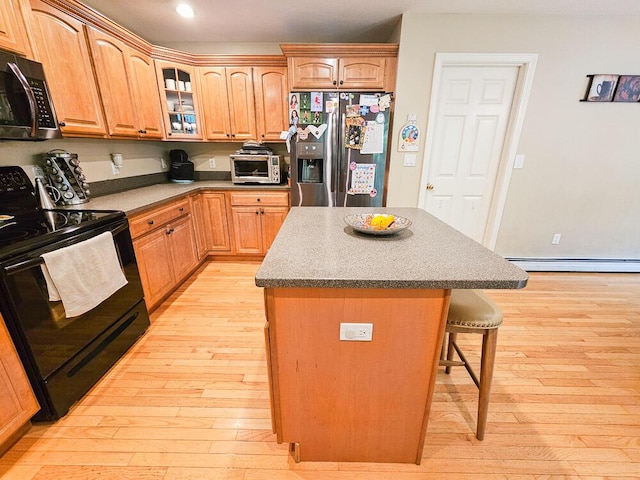 kitchen with a center island, stainless steel refrigerator with ice dispenser, glass insert cabinets, light wood-style floors, and black range with electric cooktop