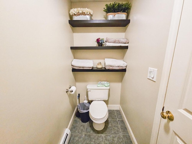 bathroom featuring baseboard heating, tile patterned flooring, toilet, and baseboards