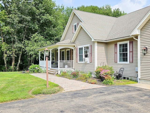 view of front of home featuring a front lawn, a porch, and roof with shingles