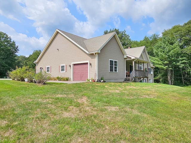 view of front facade with a shingled roof, a front yard, covered porch, and an attached garage