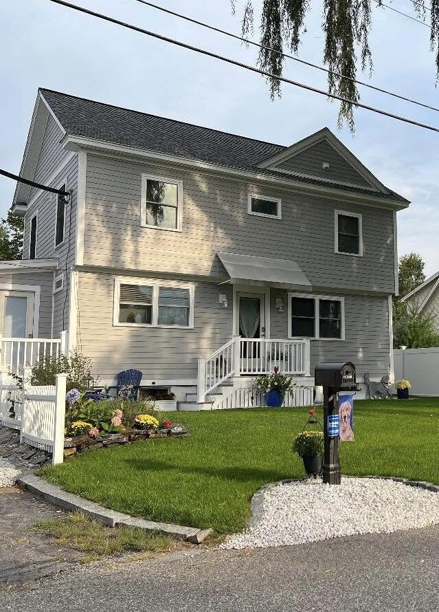 colonial-style house with a front yard and fence