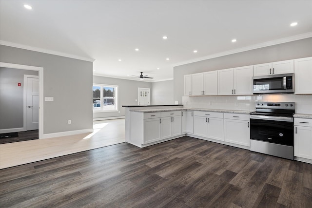 kitchen with crown molding, dark wood-type flooring, stainless steel appliances, tasteful backsplash, and white cabinets