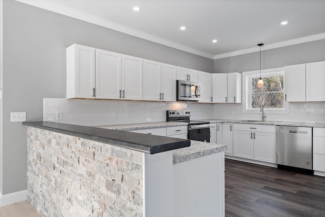 kitchen featuring sink, hanging light fixtures, kitchen peninsula, stainless steel appliances, and white cabinets