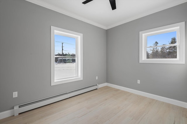 spare room featuring a baseboard heating unit, light hardwood / wood-style flooring, and a healthy amount of sunlight