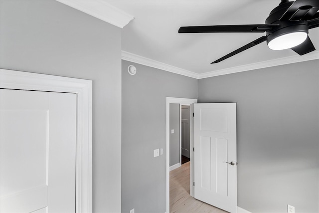 unfurnished bedroom featuring ceiling fan, ornamental molding, and light wood-type flooring