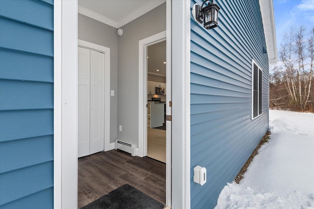 snow covered property entrance with baseboard heating