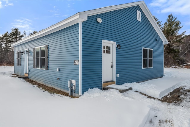 view of snow covered rear of property