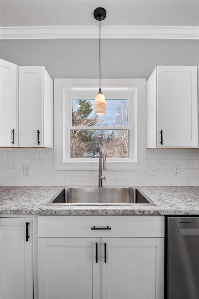 kitchen featuring pendant lighting, dishwasher, sink, white cabinets, and decorative backsplash