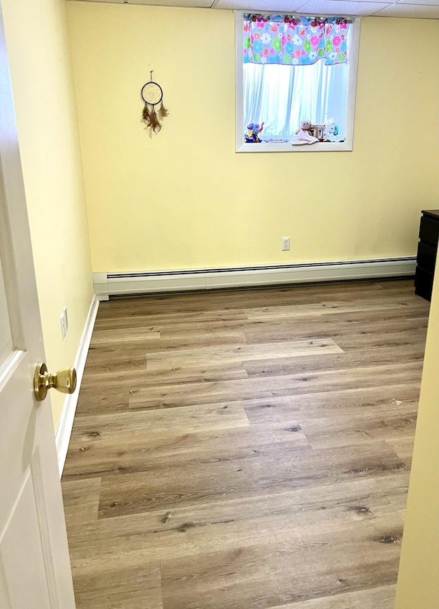 unfurnished room featuring a baseboard radiator and light wood-type flooring