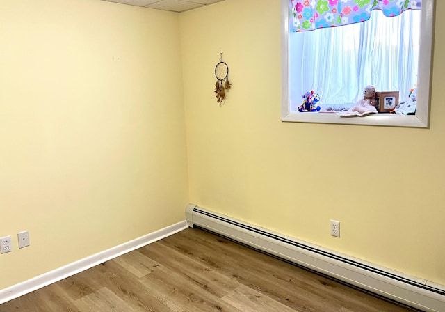 spare room featuring a baseboard radiator and hardwood / wood-style floors