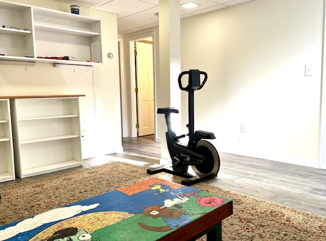 workout room featuring wood-type flooring and a drop ceiling