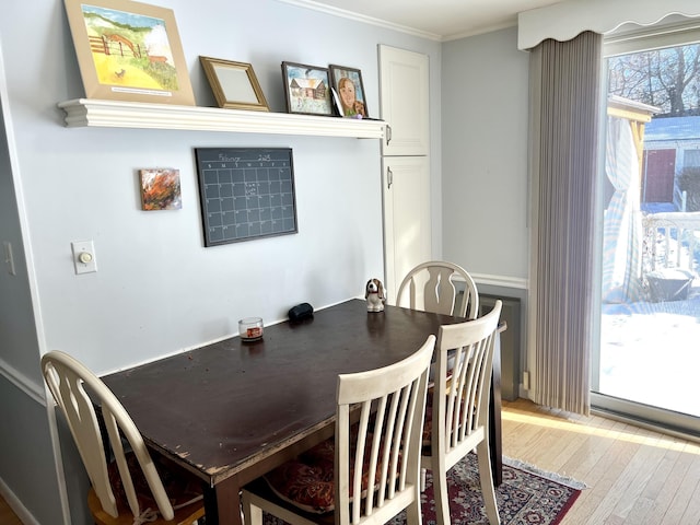 dining area featuring hardwood / wood-style floors and crown molding