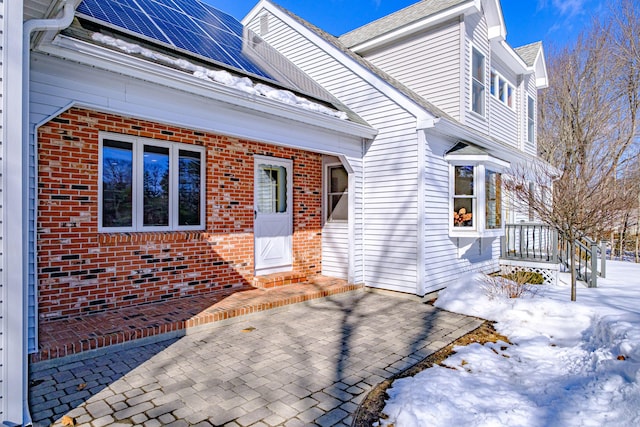 view of front of house with solar panels and brick siding