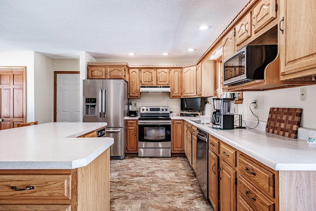 kitchen featuring stainless steel appliances, recessed lighting, light countertops, a textured ceiling, and under cabinet range hood