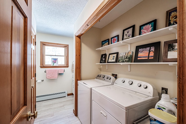 washroom with washing machine and dryer, a baseboard heating unit, light wood-style flooring, and a textured ceiling