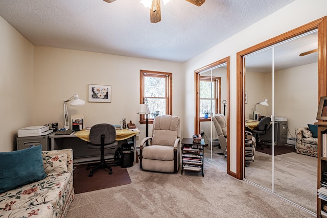 carpeted home office with a textured ceiling and a ceiling fan