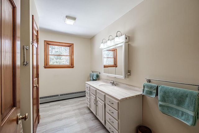 bathroom featuring baseboard heating, wood finished floors, and vanity