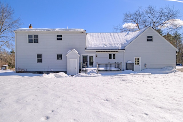 snow covered house with a wooden deck