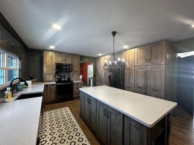 28 Grendell Rd, Mapleton, ME 04757 - kitchen featuring dark hardwood / wood-style floors, decorative light fixtures, sink, a center island, and black appliances