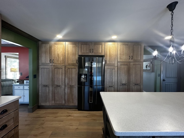 28 Grendell Rd, Mapleton, ME 04757 - kitchen featuring hanging light fixtures, black refrigerator with ice dispenser, and wood-type flooring