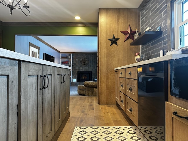 28 Grendell Rd, Mapleton, ME 04757 - kitchen with a tiled fireplace, ornamental molding, and light hardwood / wood-style flooring