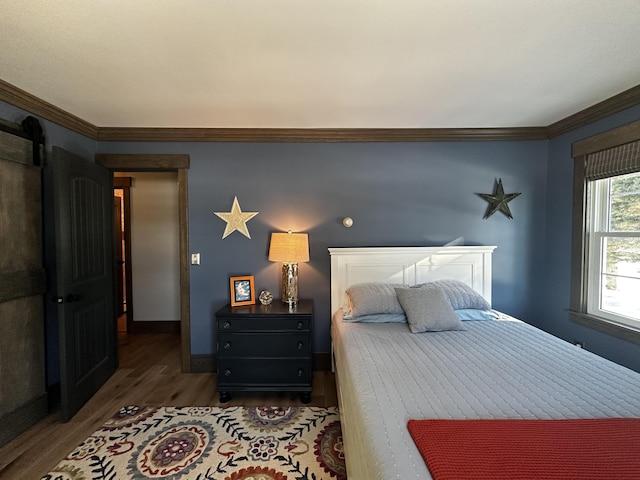 28 Grendell Rd, Mapleton, ME 04757 - bedroom with crown molding, a barn door, and hardwood / wood-style floors
