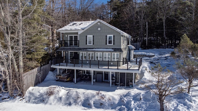 snow covered property featuring stairway, fence, and a balcony