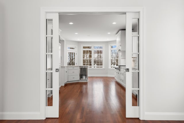 spacious closet with dark wood-type flooring and beverage cooler