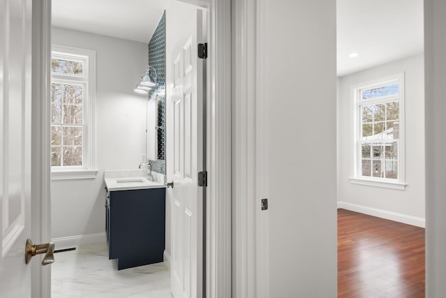 bathroom with marble finish floor, recessed lighting, vanity, and baseboards