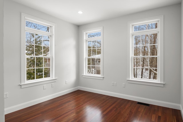 interior space featuring dark wood-style flooring, visible vents, and baseboards