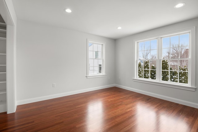 unfurnished room featuring baseboards, dark wood-type flooring, and recessed lighting