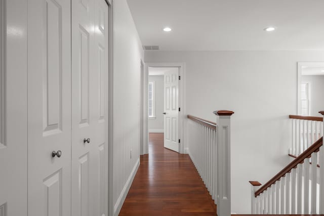 hallway with visible vents, baseboards, dark wood-style floors, an upstairs landing, and recessed lighting