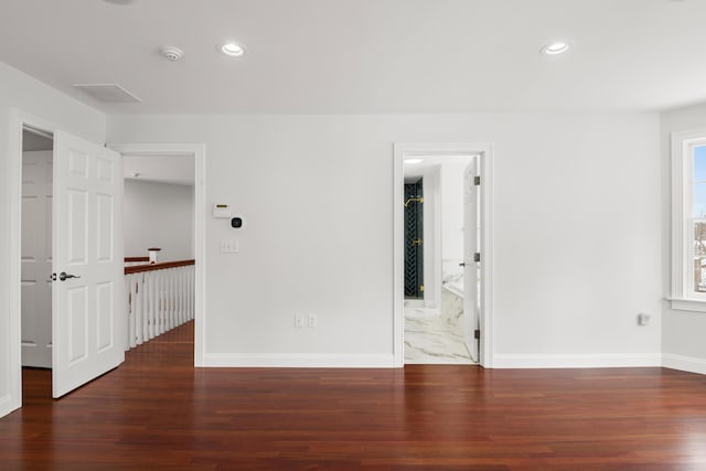 empty room featuring recessed lighting, dark wood-style flooring, and baseboards