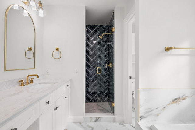 bathroom featuring marble finish floor, a shower stall, and vanity