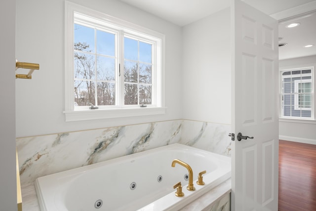 full bath with a tub with jets, wood finished floors, and recessed lighting