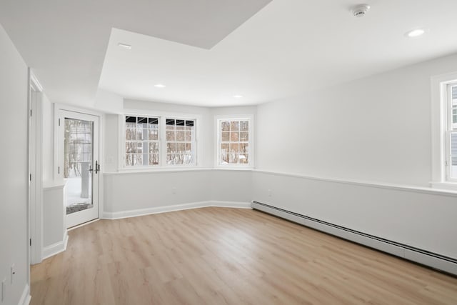 unfurnished room featuring a baseboard heating unit, recessed lighting, baseboards, and light wood finished floors